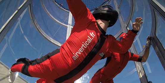 Photo de deux personnes dans un simulateur de chute libre de la société air vertical.